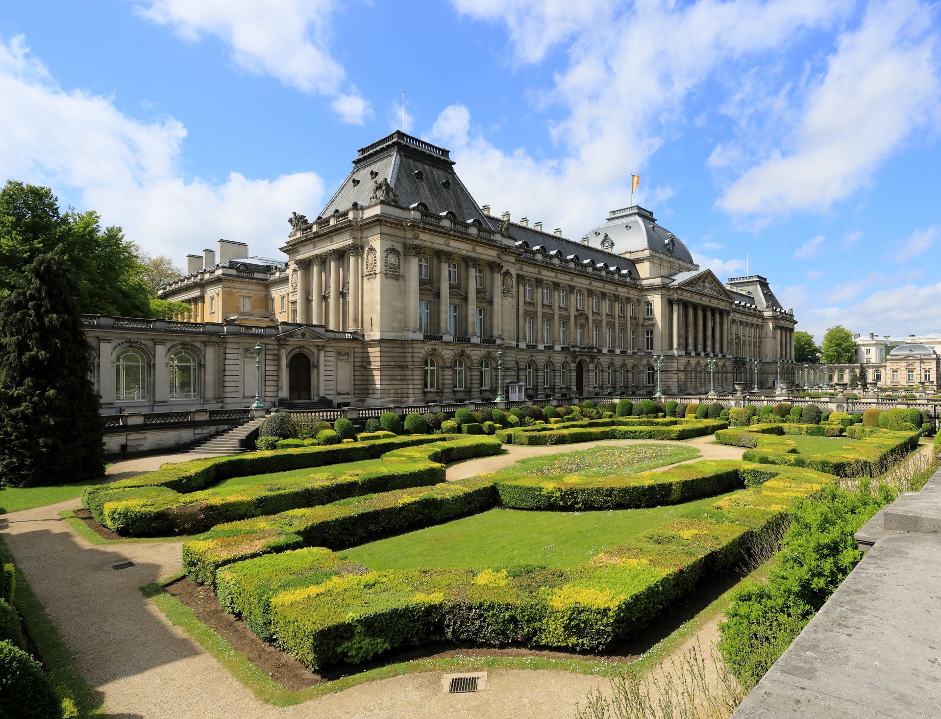 The Royal Palace of Brussels and its formal gardens under a blue sky